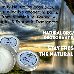 Op de afbeelding: Twee witte deodorantbalsemcontainers met een groen boomlogo en de tekst "Natural Deodorant" op het etiket. De containers staan voor een schilderachtige achtergrond van een waterval en een bewolkte lucht. De tekst "Natural Organic Deodorant Balm" en "Stay Fresh The Natural Way" is ook zichtbaar.