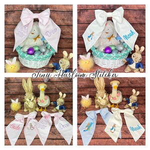 May include: Four personalized Easter baskets with bunny and duck figurines, decorated with pink and blue bows. The bows are embroidered with the names "Drew", "Noah", "Cade", and "Noah" and the text "My First Easter 2023".