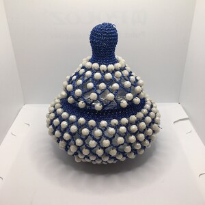 May include: A blue and white beaded gourd-shaped container with a crocheted top.