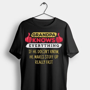 May include: Black t-shirt with the text "GRANDPA KNOWS EVERYTHING" in yellow and red, with thumbs-up graphics. The shirt also says "IF HE DOESN'T KNOW, HE MAKES STUFF UP REALLY FAST" in white text.