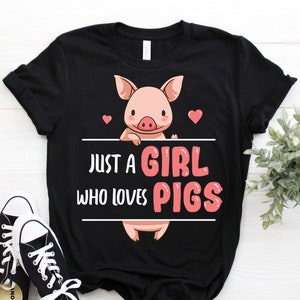 May include: Black t-shirt with a pink pig illustration and the text "Just a girl who loves pigs".