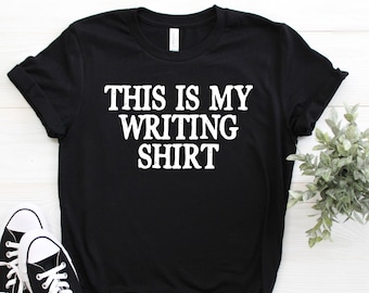 May include: Black t-shirt with white text that reads "This is my writing shirt".