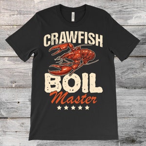 May include: Black t-shirt with a crawfish illustration and the text "Crawfish Boil Master" with five stars below.