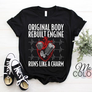 Könnte beinhalten: Schwarzes T-Shirt mit einer weißen Grafik eines Herzens mit einem überholten Motor darin. Der Text lautet "Original Body Rebuilt Engine Runs Like A Charm".