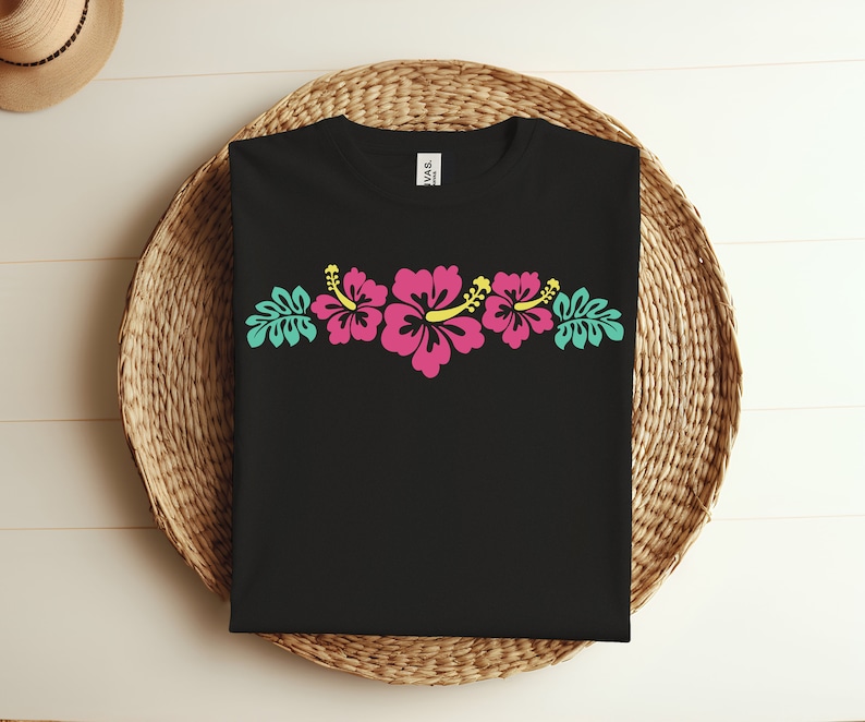 May include: Black t-shirt with a row of pink hibiscus flowers with yellow centers and green leaves.