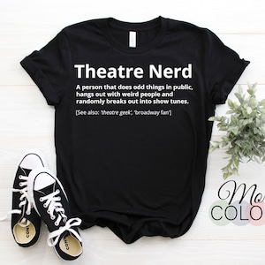 May include: Black t-shirt with the white text "Theatre Nerd" and a definition. The shirt is styled with black and white trainers. The words "More Colors" are also displayed.