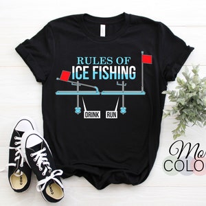 May include: Black t-shirt with a white graphic of a seesaw with the words "Rules of Ice Fishing" and "Drink" and "Run" on it. The seesaw has a red flag on each end.