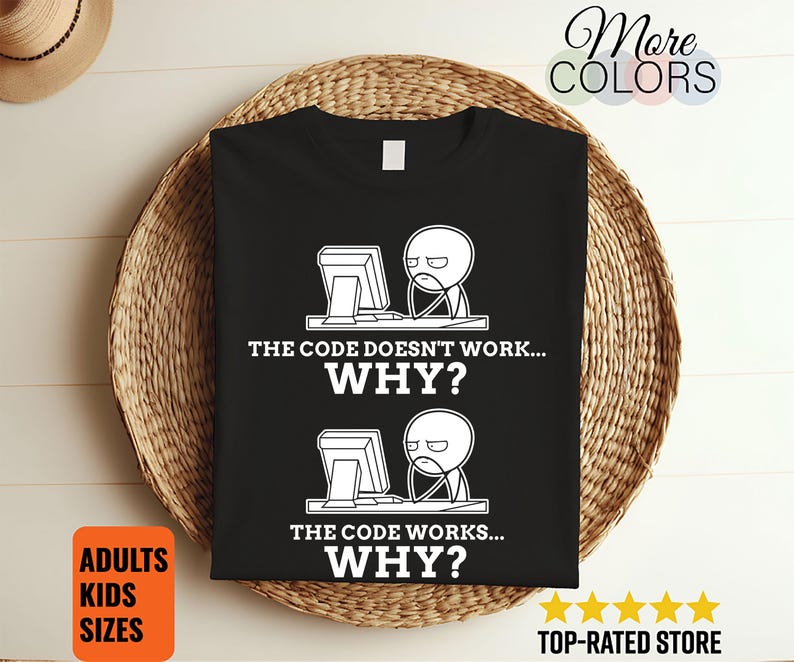 May include: Black t-shirt with a white graphic of a person at a computer, with the text "THE CODE DOESN'T WORK... WHY?" and "THE CODE WORKS... WHY?". The shirt also has the text "ADULTS KIDS SIZES".