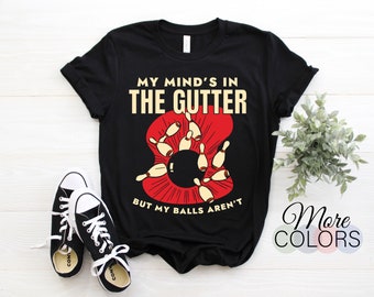 May include: Black t-shirt with a bowling-themed graphic. The graphic shows bowling pins and a bowling ball with the text "My mind's in the gutter but my balls aren't".
