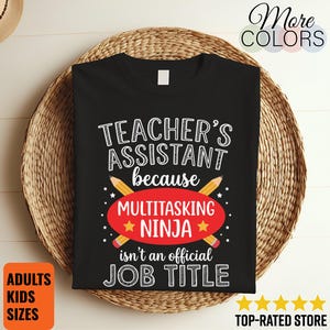 以下が含まれることがあります： 「TEACHER'S ASSISTANT because MULTITASKING NINJA isn't an official JOB TITLE」という白と黄色の文字がプリントされた黒いTシャツ。デザインには、交差した2本の黄色い鉛筆と、ninjaという単語の後ろにある赤い楕円形の図形が含まれています。