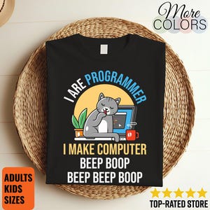 May include: Black t-shirt with a graphic of a gray cat sleeping next to a laptop. Text on the shirt reads "I ARE PROGRAMMER, I MAKE COMPUTER, BEEP BOOP, BEEP BEEP BOOP." The shirt also has the words "ADULTS, KIDS, SIZES" on the bottom left.