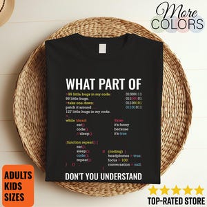 May include: Black t-shirt with white text that reads "WHAT PART OF DON'T YOU UNDERSTAND" and code-related phrases. The shirt also has a list of code and binary numbers. The shirt is displayed on a woven basket.
