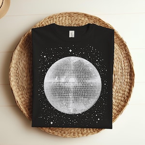 Könnte beinhalten: Schwarzes T-Shirt mit einem weißen Discokugel-Motiv auf schwarzem Hintergrund mit weißen Sternen.