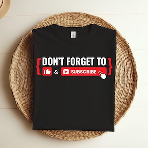 May include: Black t-shirt with the text "DON'T FORGET TO { }" and icons for a thumbs up and a play button with the text "SUBSCRIBE" underneath.