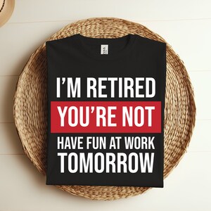 May include: Black t-shirt with white text that reads "I'm Retired You're Not Have Fun At Work Tomorrow". The text is in a red box.