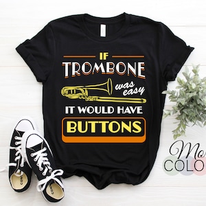 May include: Black t-shirt with a yellow graphic of a trombone and the text "If trombone was easy it would have buttons".