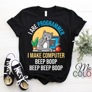 May include: Black t-shirt with a graphic of a cat working on a computer, with the text "I ARE PROGRAMMER" and "I MAKE COMPUTER BEEP BOOP BEEP BEEP BOOP". Includes a pair of black and white sneakers.