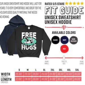 May include: Black unisex sweatshirt with the text "FREE HUGS" and a graphic of two people wrestling. The sweatshirt is available in black, navy, dark heather, and red. The size chart shows the width and length in inches for sizes S through 5XL.