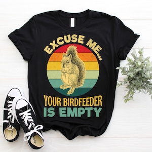 May include: Black t-shirt featuring a vintage-style graphic of a squirrel and the text "Excuse me... Your birdfeeder is empty".