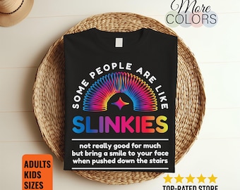 May include: Black t-shirt with a colorful slinky design and the text "SOME PEOPLE ARE LIKE SLINKIES". The shirt also includes the text "not really good for much but bring a smile to your face when pushed down the stairs".