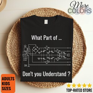 May include: Black t-shirt featuring a white circuit diagram and text. The text on the shirt says "What Part of... Don't you Understand?" with additional text indicating "ADULTS KIDS SIZES" and "TOP-RATED STORE".