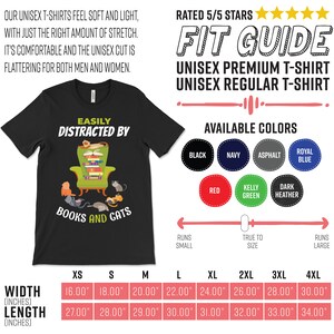May include: Black unisex t-shirt with a graphic of a cat reading a book in a chair surrounded by other cats. The text reads "Easily Distracted By Books and Cats". The shirt is available in sizes XS to 4XL and in a variety of colors.