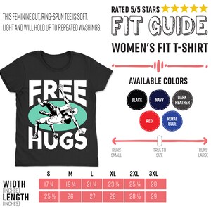 May include: Black women's fit t-shirt with a green circle and white text that says "Free Hugs". The graphic inside the circle shows two people wrestling. The size chart shows the width and length in inches for sizes S through 3XL.