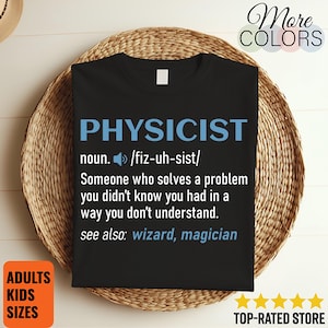 May include: A black t-shirt featuring the word PHYSICIST in blue, followed by the noun definition: Someone who solves a problem you didn't know you had in a way you don't understand. The text also includes a speaker icon and see also: wizard, magician.