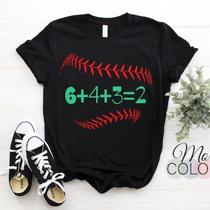 Könnte beinhalten: Schwarzes T-Shirt mit einem roten Baseball-Motiv und dem Text "6+4+3=2" in Grün.
