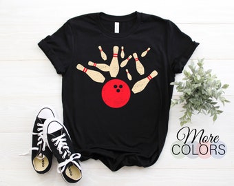 May include: Black t-shirt with a vintage-style graphic of a bowling ball and pins. The graphic is in red, white, and beige.