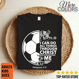 May include: Black t-shirt with a white soccer ball graphic and the text "I CAN DO ALL THINGS THROUGH CHRIST WHO STRENGTHENS ME" from Philippians 4:13. The shirt also has a soccer player graphic.
