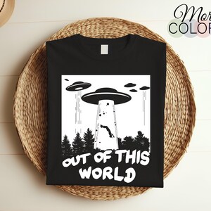 May include: Black t-shirt with a white graphic of a UFO and the text "Out of this world".