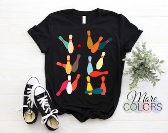 May include: Black t-shirt with a colorful bowling pin design. The pins are arranged in a random pattern and are in various shades of red, orange, yellow, green, blue, and brown.