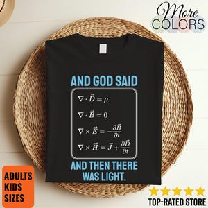 May include: A black short-sleeved t-shirt featuring the light blue text AND GOD SAID AND THEN THERE WAS LIGHT and a white graphic box containing Maxwell's equations in the center. The shirt has a white neck label and a simple crew neckline.