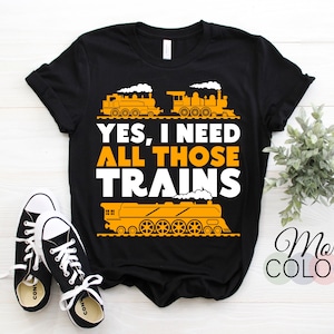 May include: Black t-shirt with a white graphic of three trains and the text "YES, I NEED ALL THOSE TRAINS".
