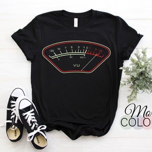 May include: Black t-shirt with a graphic of a VU meter, a common audio recording device. The meter is red and yellow with black markings. The text "VU" is below the meter.