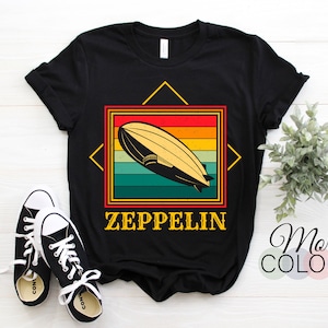 May include: Black t-shirt with a vintage-style graphic of a dirigible airship with the text "ZEPPELIN" below it.
