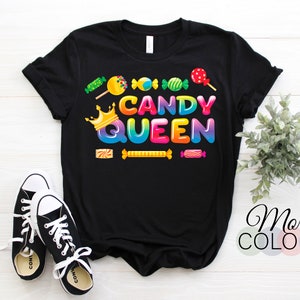 May include: Black t-shirt featuring a rainbow graphic that reads "Candy Queen". The graphic includes a crown and candy images.