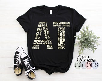 May include: Black t-shirt with the word "ATHLETE" spelled out vertically using words related to athletic training, such as "trainer", "exercise", "physiology", "rehabilitation", and "ankle wraps".