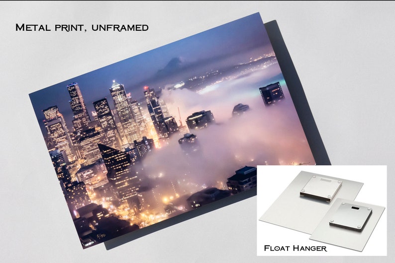 May include: A metal print of a city skyline at night with fog rolling in. The print is unframed and comes with a float hanger.