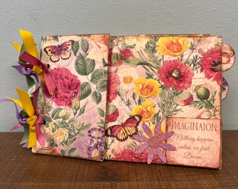 Álbum de fotos con bolsa de papel y flores de primavera