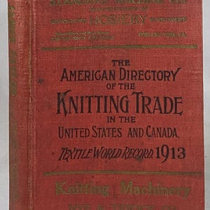 May include: A vintage red book titled "The American Directory of the Knitting Trade in the United States and Canada, Textile World Record 1913." Gold lettering and text details the book's publisher and subject matter.