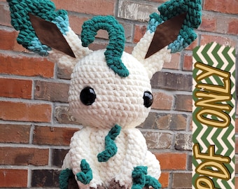 May include: White crocheted plush toy with green and brown accents. The toy has large eyes and a curled tail.