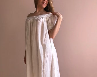 May include: A white off-the-shoulder dress with short sleeves and a gathered bodice. The dress is made of a lightweight fabric and has a flowing silhouette.