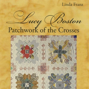 May include: Book cover titled "Lucy Boston Patchwork of the Crosses" by Linda Franz. The cover features a detailed patchwork quilt design with four central cross-shaped patterns in various colors and patterns, set against a cream background.
