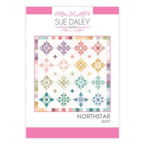 May include: A quilt pattern package with the text "SUE DALEY DESIGNS" at the top. The quilt design features colourful star patterns in shades of pink, purple, green, and yellow on a white background. The text "NORTHSTAR QUILT" is at the bottom.