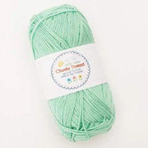 May include: A ball of light green yarn with a white label that says "Chunky Thread" with a colourful flower design.