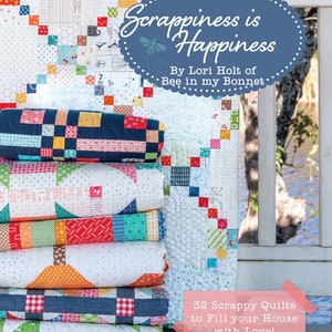Könnte beinhalten: Ein Stapel bunter Patchwork-Decken mit dem Text "Scrappiness is Happiness" und "32 Scrappy Quilts to Fill your House with Love!" Die Decken sind aus verschiedenen Stoffen und Mustern gefertigt.