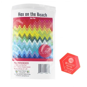 May include: A complete paper piece pack for a quilt pattern called "Hex on the Beach" by Tula Pink. The pack includes a pattern, acrylic template, and paper pieces for a 42 inch by 59 inch quilt. The image shows a colorful hexagon pattern with a red hexagon template.