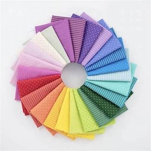 Puede incluir: Una colección de 20 cuadrados de tela en un arcoíris de colores, cada uno con un patrón diferente, incluyendo lunares, rayas y colores sólidos.